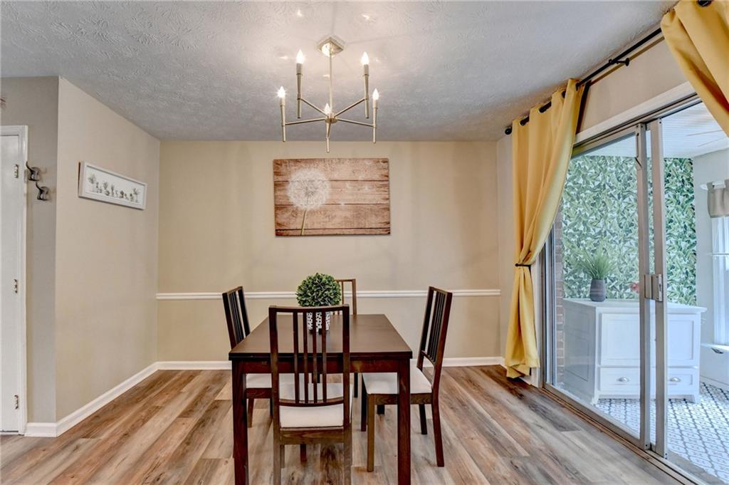 6700 Roswell Road, Unit 22B Atlanta, GA 30328 - Photo 8 of 34 a view of a dining room with furniture wooden floor and a chandelier