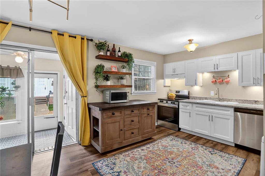 6700 Roswell Road, Unit 22B Atlanta, GA 30328 - Photo 9 of 34 a kitchen with stainless steel appliances granite countertop a stove a sink and a refrigerator