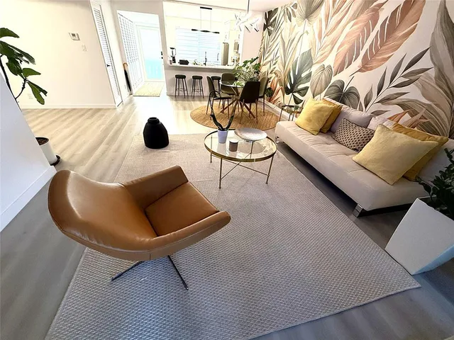 a view of a hallway with wooden floor and a potted plant