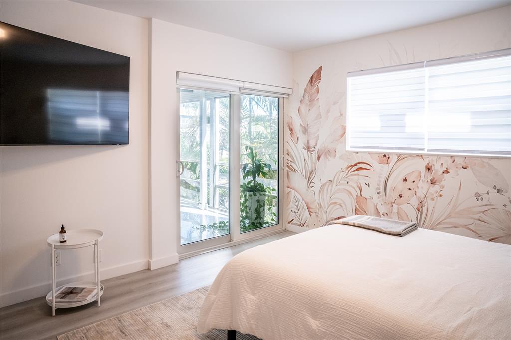 10 Southeast 13th Street, Unit B3 Boca Raton, FL 33432 - Photo 23 of 85 a bedroom with a large bed and a flat tv screen on dresser