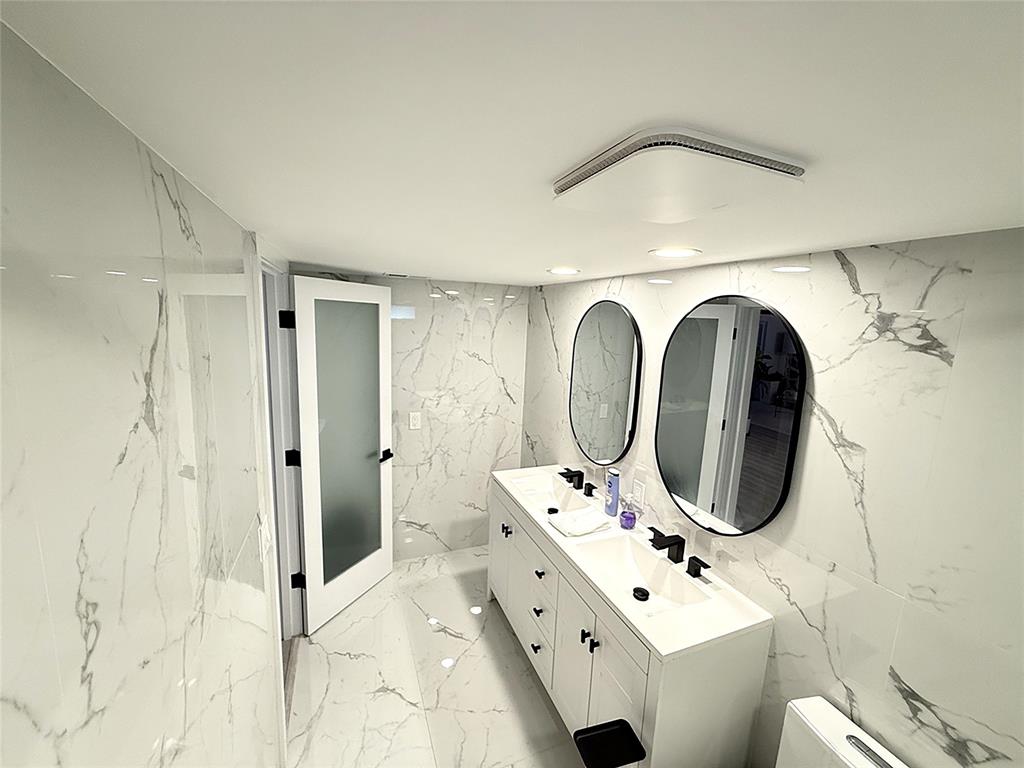 10 Southeast 13th Street, Unit B3 Boca Raton, FL 33432 - Photo 40 of 85 a bathroom with a toilet sink and mirror