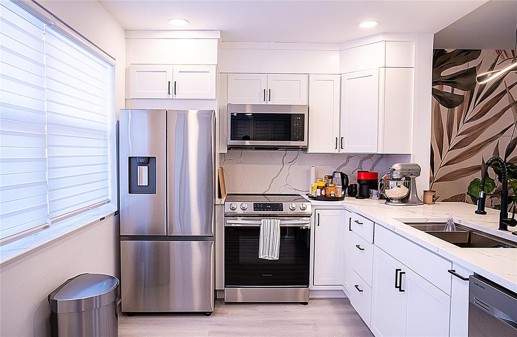 10 Southeast 13th Street, Unit B3 Boca Raton, FL 33432 - Photo 47 of 85 a kitchen with stainless steel appliances a stove microwave and sink