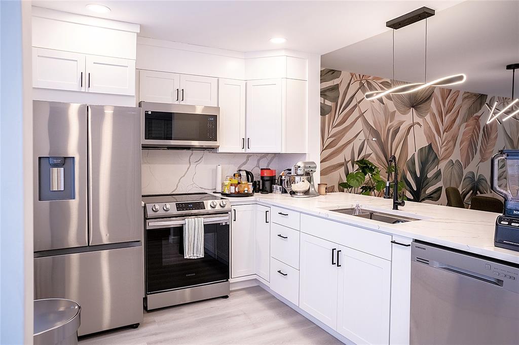 10 Southeast 13th Street, Unit B3 Boca Raton, FL 33432 - Photo 48 of 85 a kitchen with stainless steel appliances a refrigerator sink and microwave