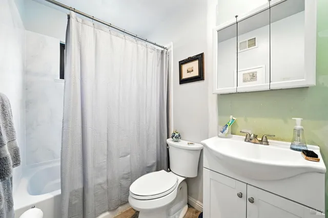 a bathroom with a sink a toilet and shower curtain