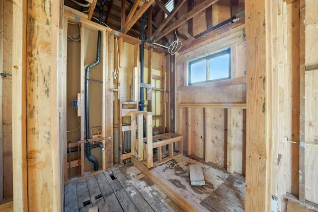 a view of a hallway with wooden floor and a living room