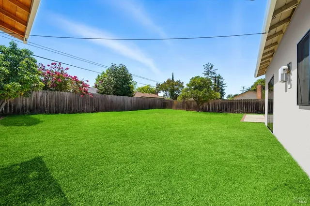 a view of yard with swimming pool and green space