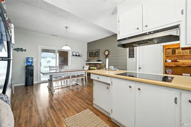a kitchen with granite countertop a sink cabinets and wooden floor