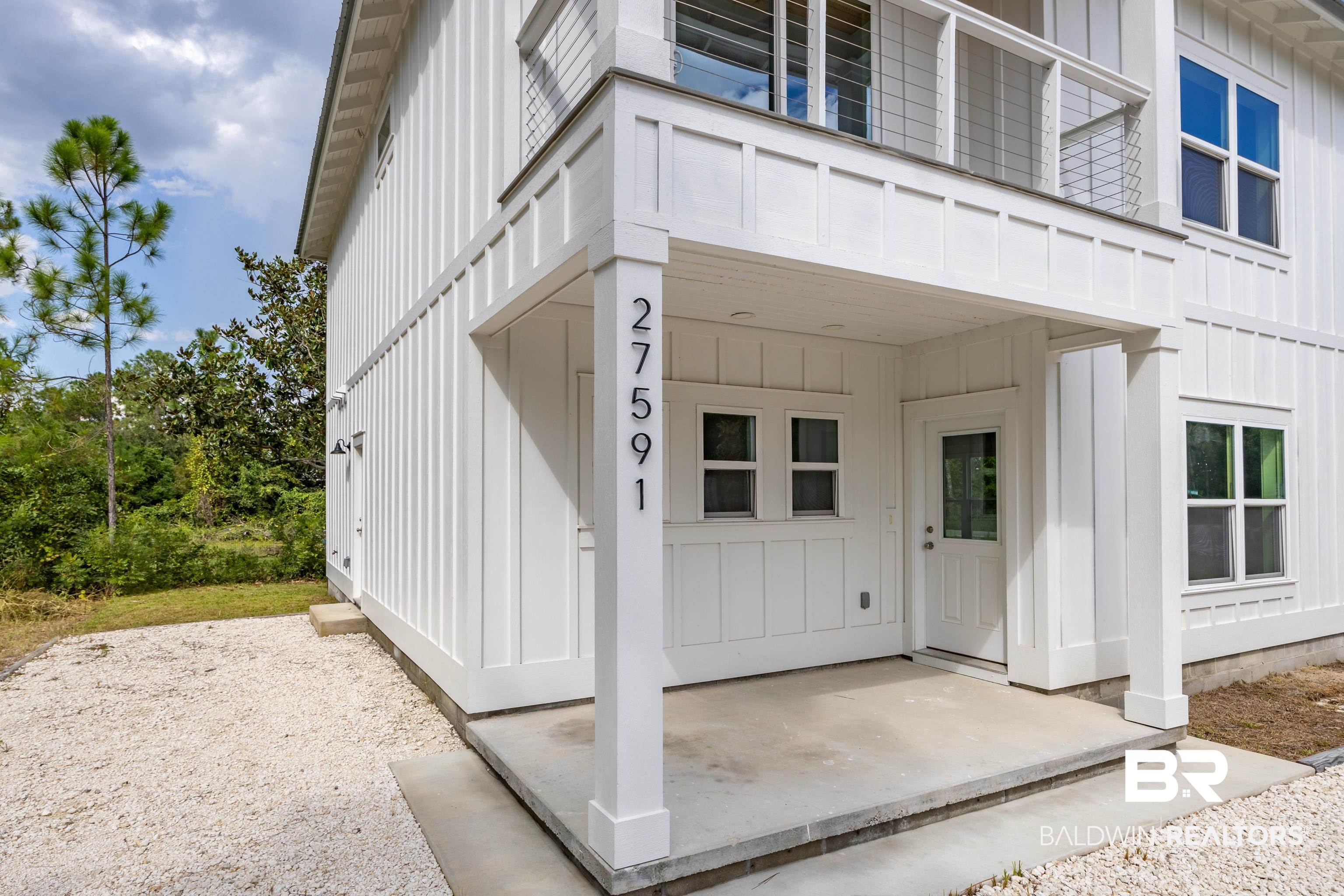27591 Canal Road Orange Beach, AL 36561 - Photo 5 of 51 Doorway to property featuring board and batten siding and covered porch