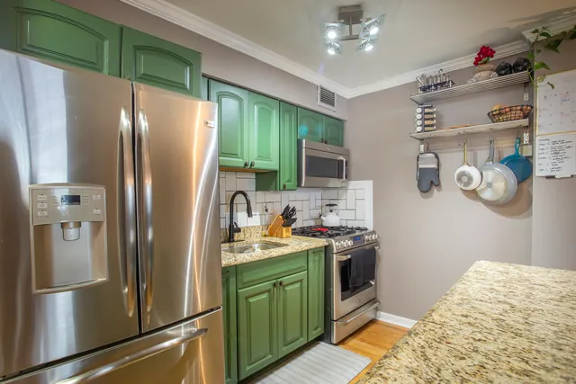 a kitchen with stainless steel appliances granite countertop a refrigerator and a sink