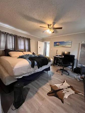 a bedroom with a bed large mirror and a desk