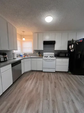 a kitchen with stainless steel appliances a sink a stove a microwave and cabinets