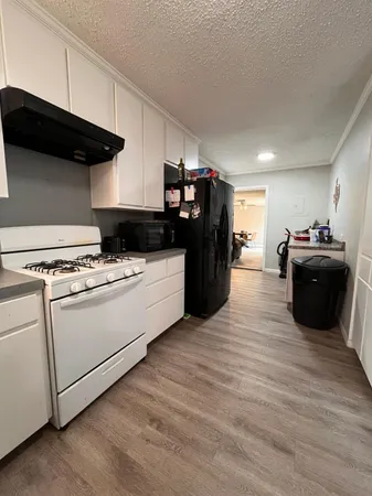 a kitchen with a cabinets and wooden floor