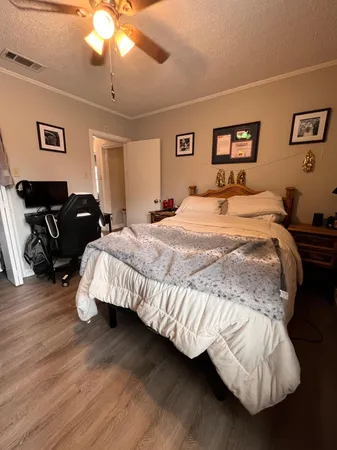 a bedroom with bed and wooden floor