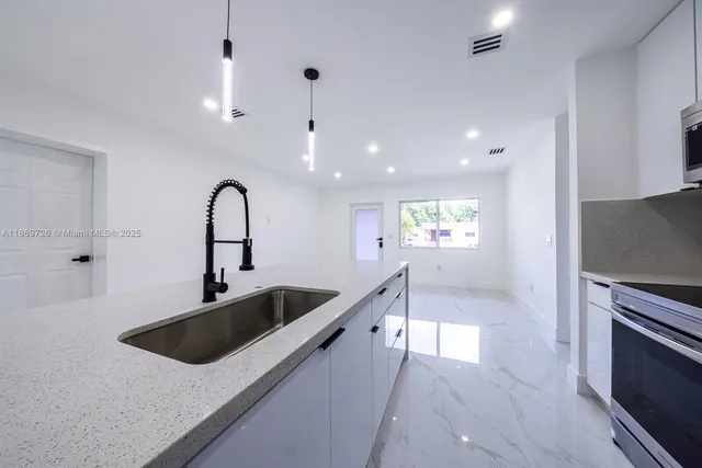 a kitchen with stainless steel appliances a sink a stove and a refrigerator