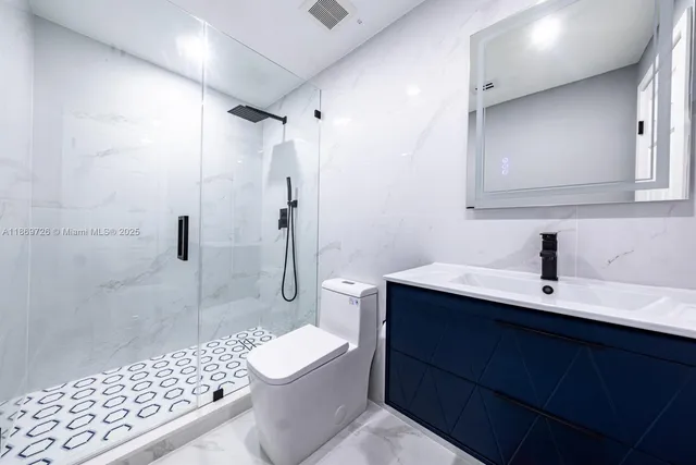 a bathroom with a sink a toilet a shower and a mirror