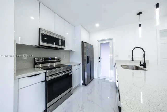 a kitchen with stainless steel appliances a stove a sink and a microwave