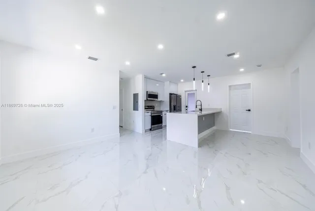 a view of kitchen with kitchen island a sink stainless steel appliances and cabinets