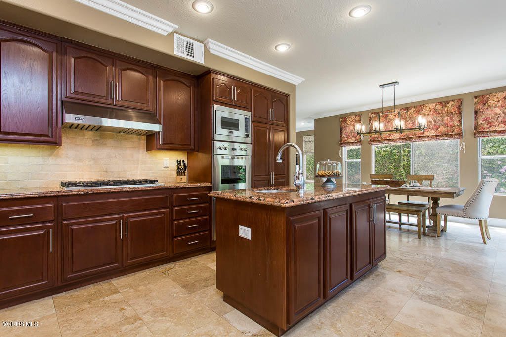 11245 Bentcreek Road Moorpark, CA 93021 - Photo 23 of 48 a kitchen with stainless steel appliances granite countertop wooden cabinets a sink and a stove