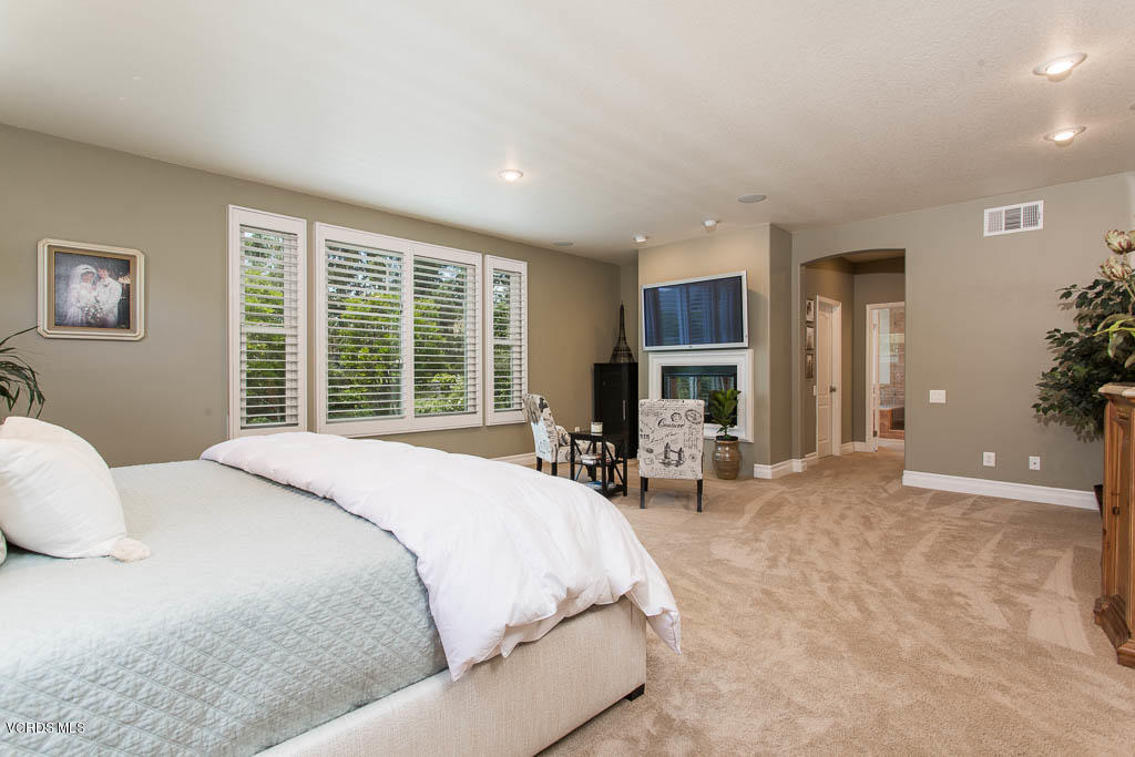 11245 Bentcreek Road Moorpark, CA 93021 - Photo 27 of 48 a bed sitting in a spacious bedroom next to a window and chair