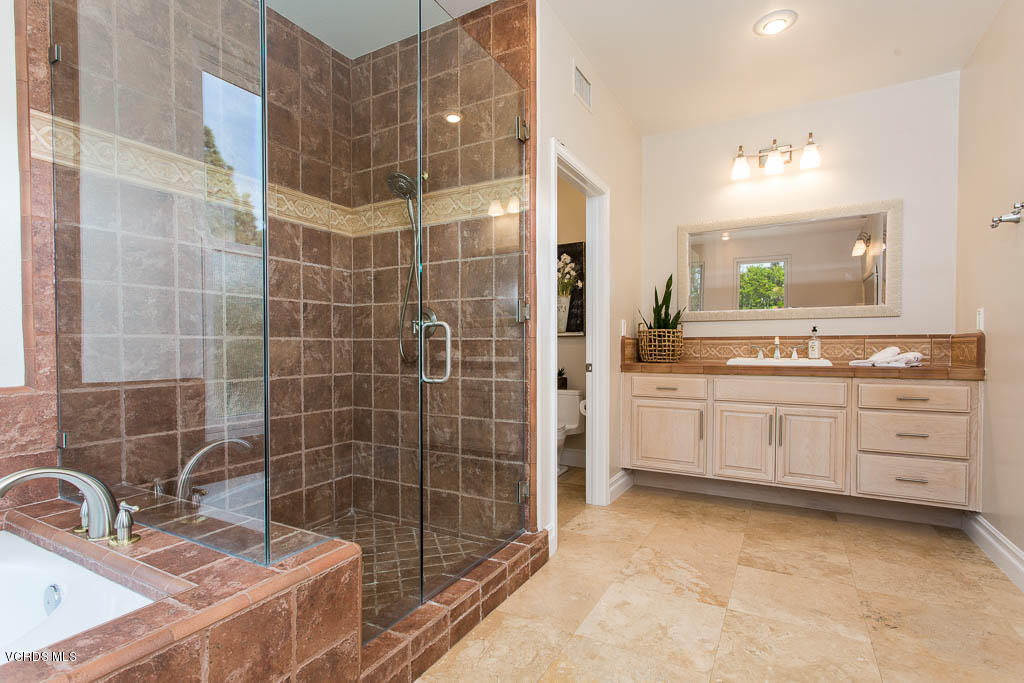 11245 Bentcreek Road Moorpark, CA 93021 - Photo 30 of 48 a bathroom with a double vanity sink a toilet a mirror and shower