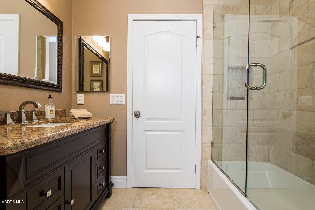 11245 Bentcreek Road Moorpark, CA 93021 - Photo 37 of 48 a bathroom with a granite countertop sink mirror and a bathtub