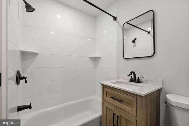 a bathroom with a sink mirror vanity and toilet