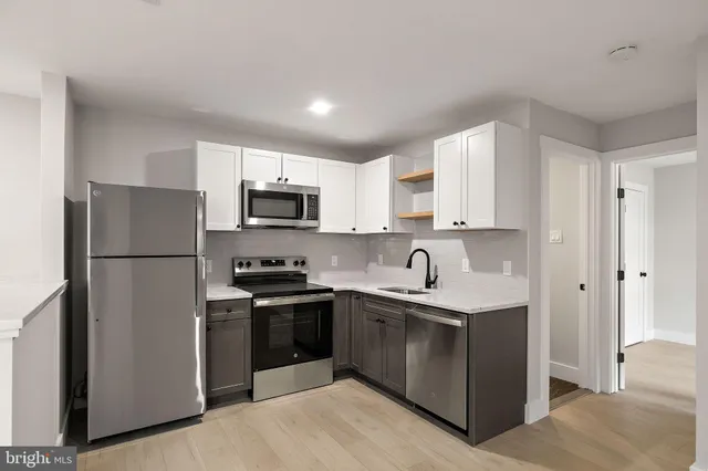 a kitchen with a sink a refrigerator a microwave and cabinets