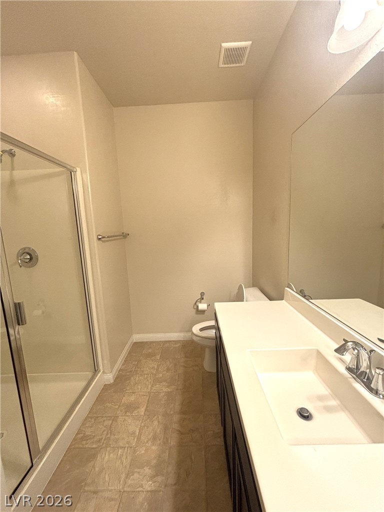 121 Elm Reed Avenue Las Vegas, NV 89113 - Photo 13 of 30 A well-appointed bathroom features a glass-enclosed shower and a vanity with an integrated sink.