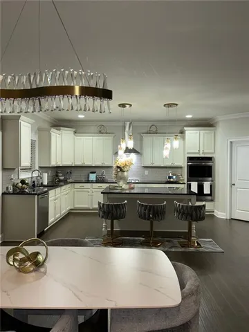 a kitchen with kitchen island granite countertop a sink and a stove