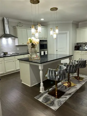 a kitchen with kitchen island granite countertop a stove a sink and a granite counter tops