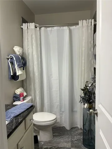 a bathroom with a sink toilet and shower curtain