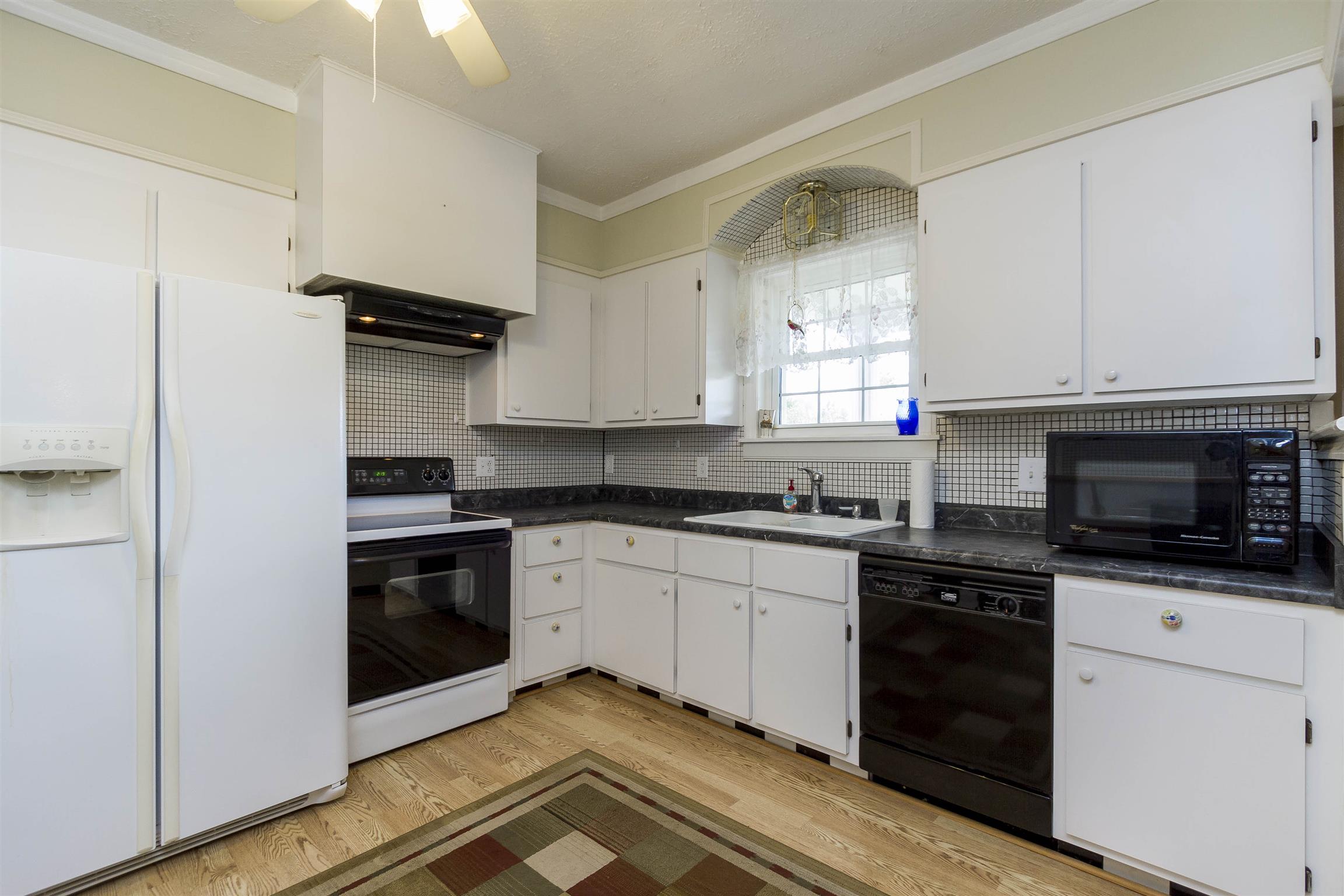 5067 Youngville Road Springfield, TN 37172 - Photo 8 of 28 a kitchen with granite countertop white cabinets and appliances