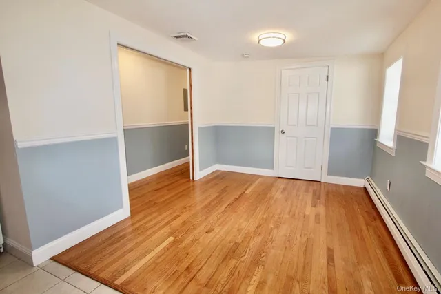 an empty room with wooden floor and closet