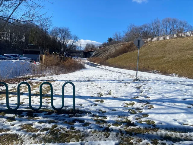 a backyard of a house with table and chairs under an umbrella