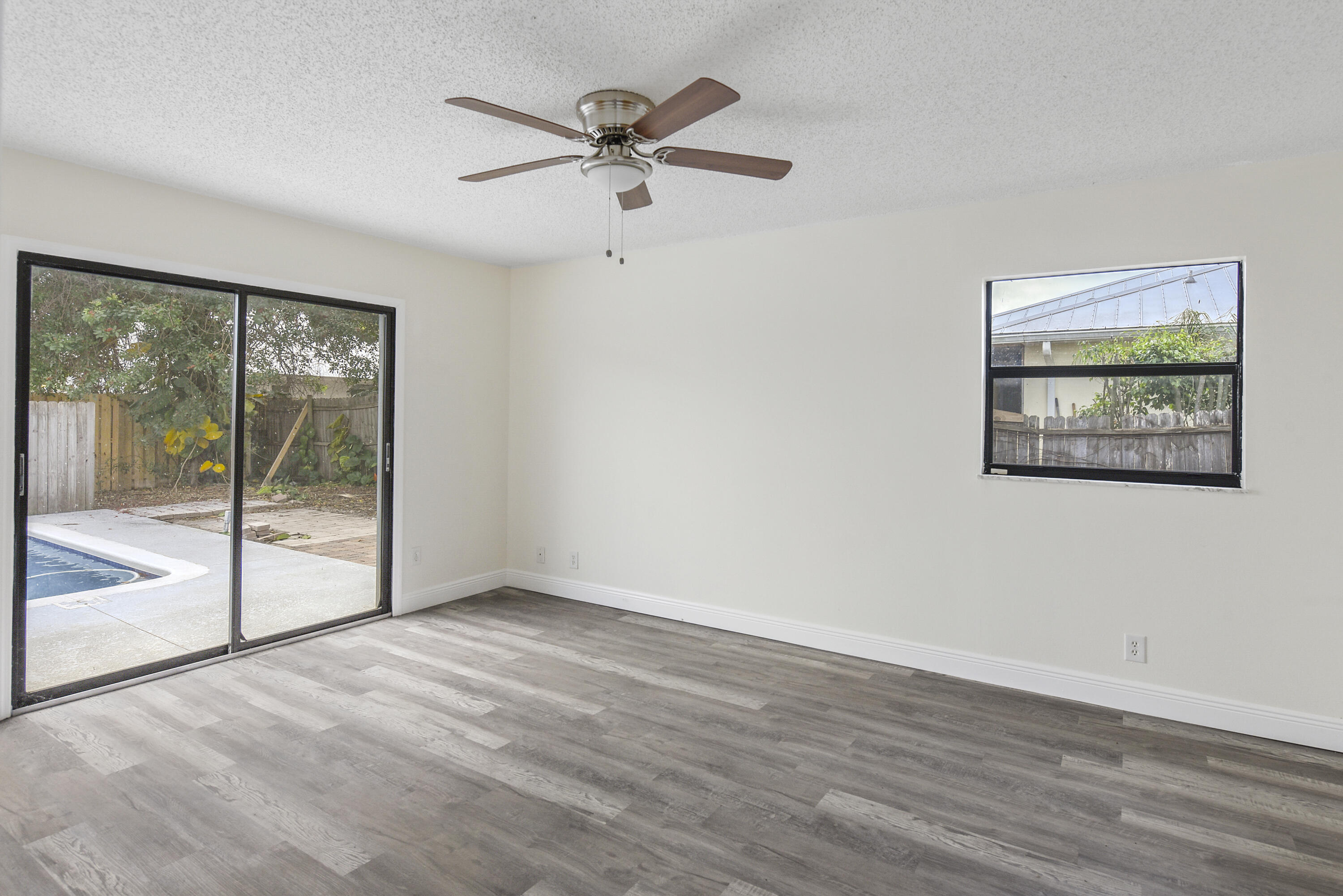 5666 Southeast Matousek Street Stuart, FL 34997 - Photo 13 of 49 wooden floor in an empty room with a window