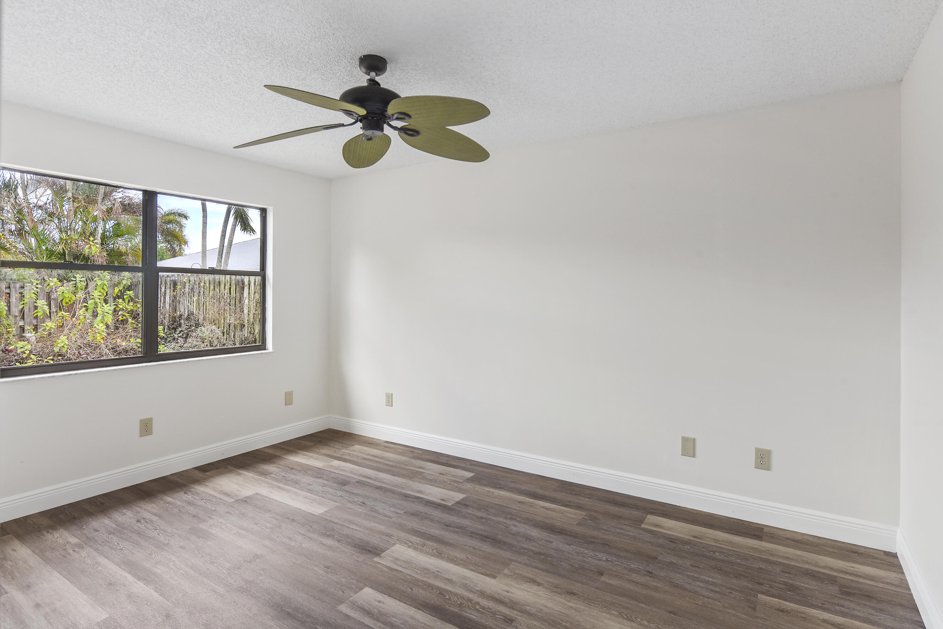 5666 Southeast Matousek Street Stuart, FL 34997 - Photo 15 of 49 a view of an empty room with wooden floor and a window