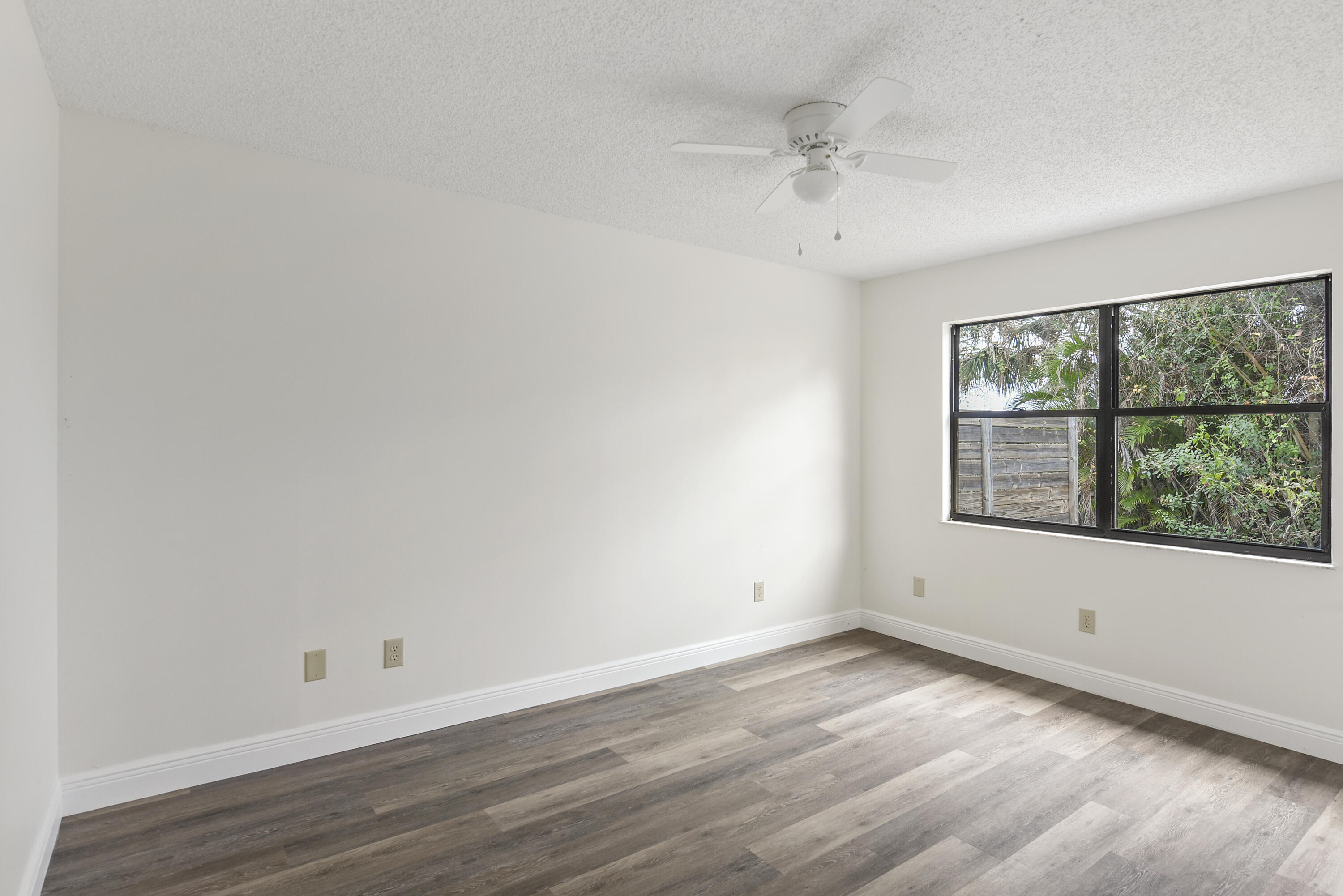 5666 Southeast Matousek Street Stuart, FL 34997 - Photo 16 of 49 wooden floor in an empty room with a window
