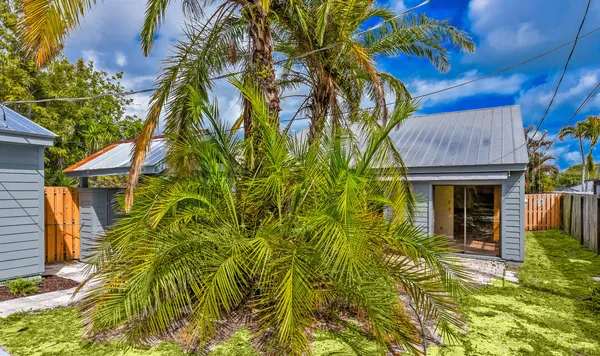 a view of a house with plants and wooden fence