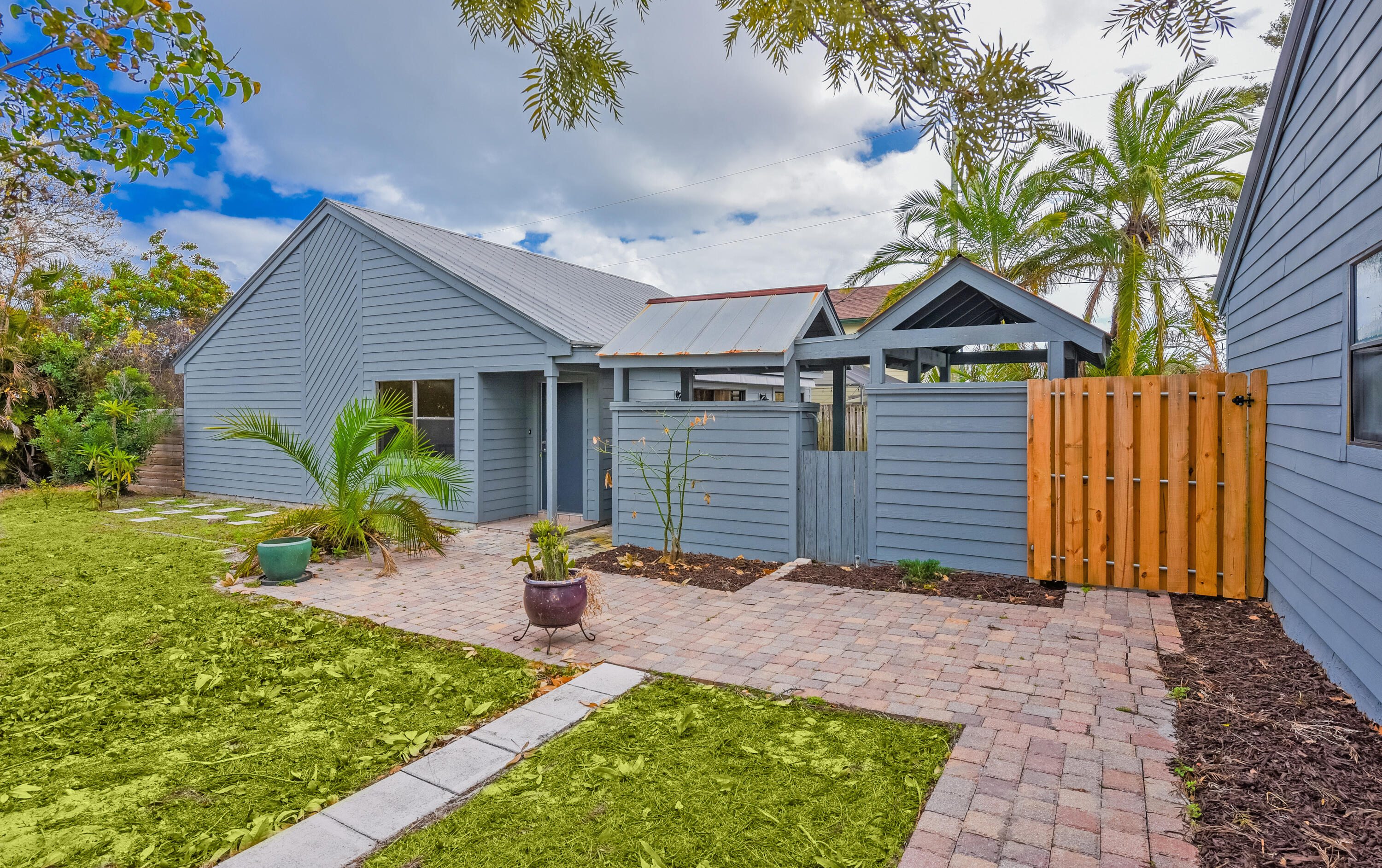 5666 Southeast Matousek Street Stuart, FL 34997 - Photo 32 of 49 a backyard of a house with table and chairs plants