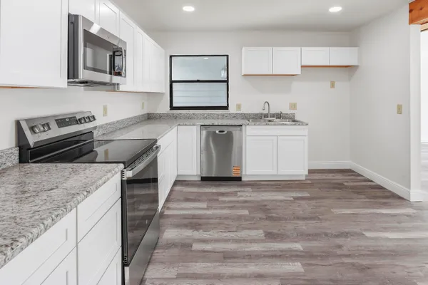 a kitchen with stainless steel appliances granite countertop a stove and a sink