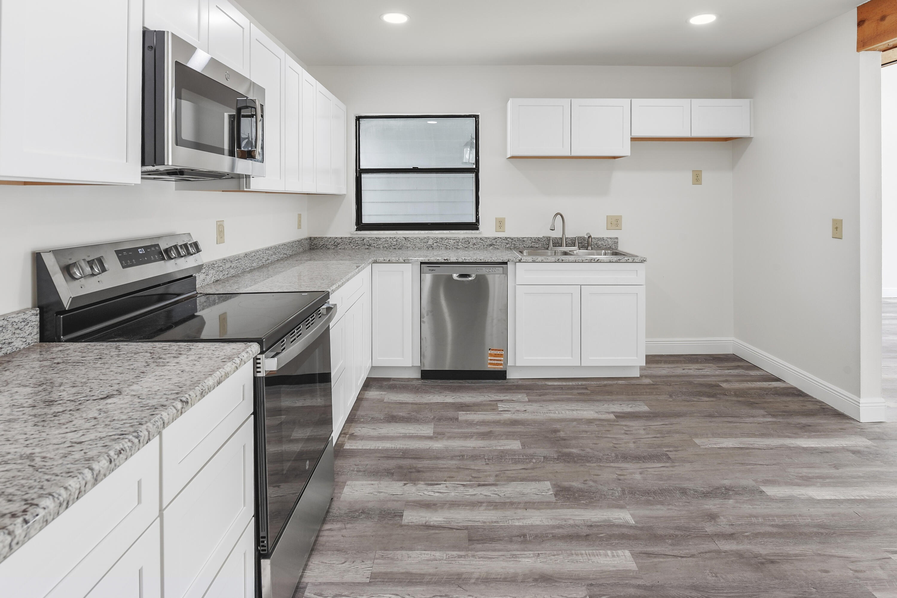 5666 Southeast Matousek Street Stuart, FL 34997 - Photo 5 of 49 a kitchen with stainless steel appliances granite countertop a stove and a sink