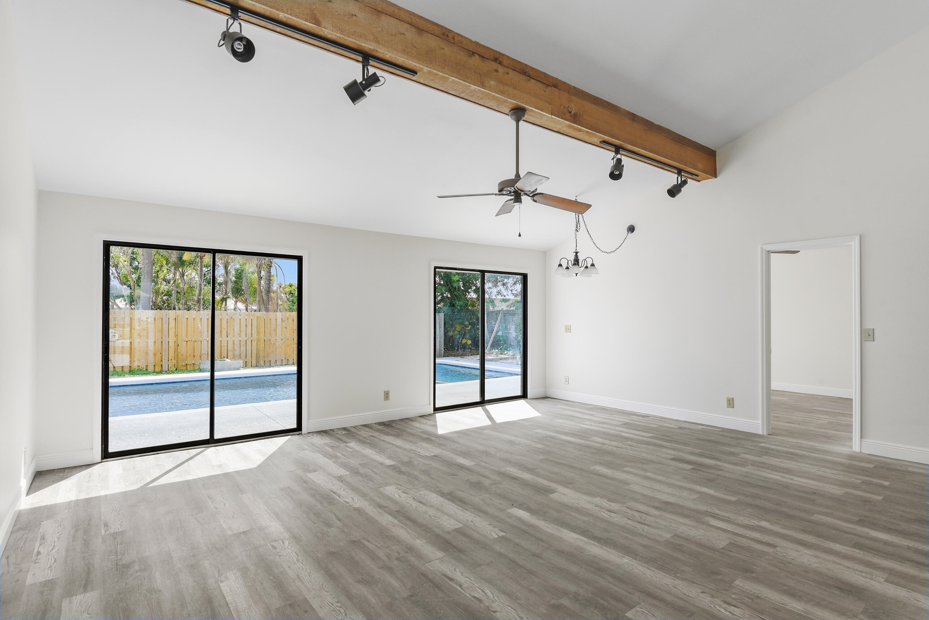 5666 Southeast Matousek Street Stuart, FL 34997 - Photo 6 of 49 a view of empty room with wooden floor and fan