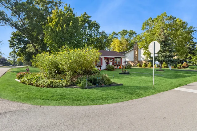 a view of a house with a big yard and potted plants