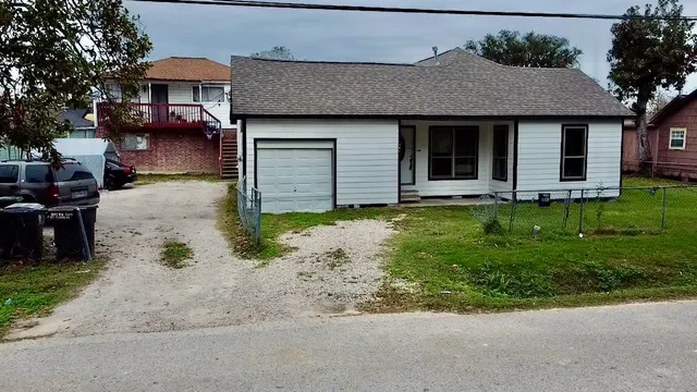 a front view of a house with a garden and trees