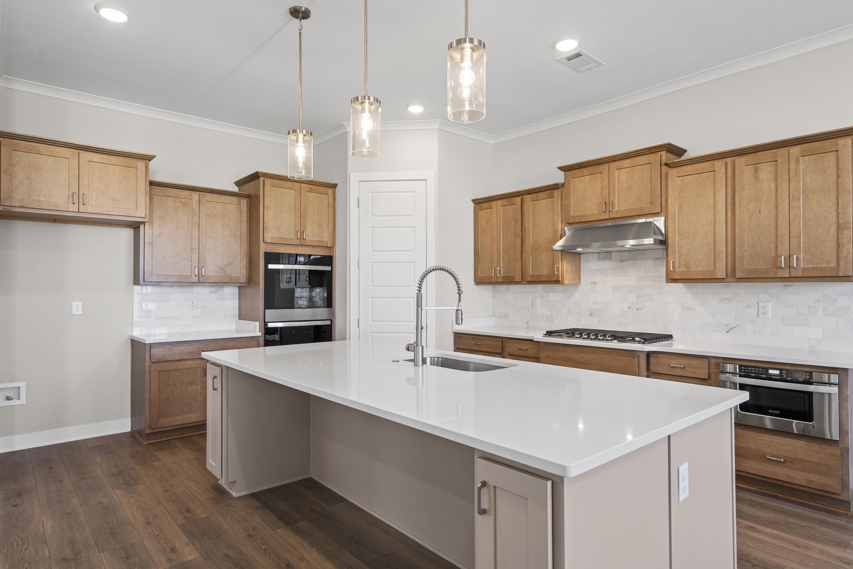 4824 Lyla Lane Collierville, TN 38017 - Photo 7 of 32 a kitchen with stainless steel appliances granite countertop a sink a stove a refrigerator and island with wooden floor