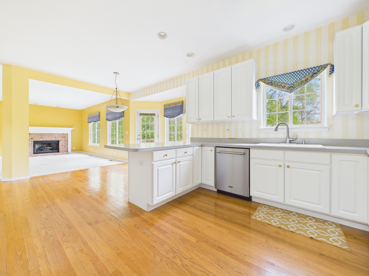7486 Abbey Road Gurnee, IL 60031 - Photo 8 of 35 a large kitchen with a lot of white cabinets and wooden floor