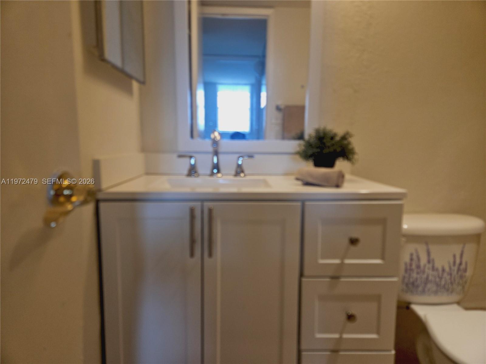 4550 Northwest 9th Street, Unit 704E Miami, FL 33126 - Photo 2 of 21 a bathroom with a sink and a mirror