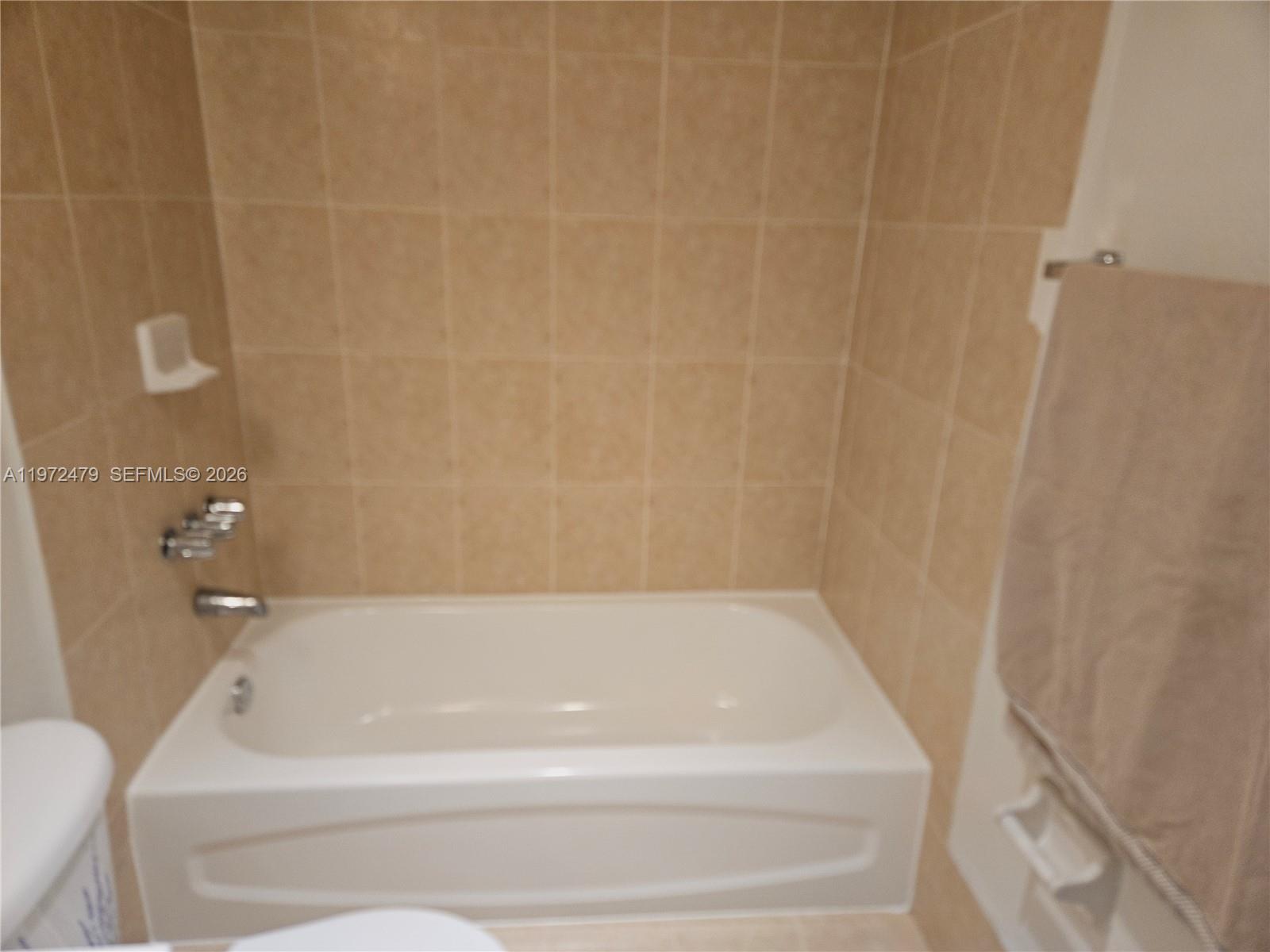 4550 Northwest 9th Street, Unit 704E Miami, FL 33126 - Photo 3 of 21 a bathroom with a bathtub