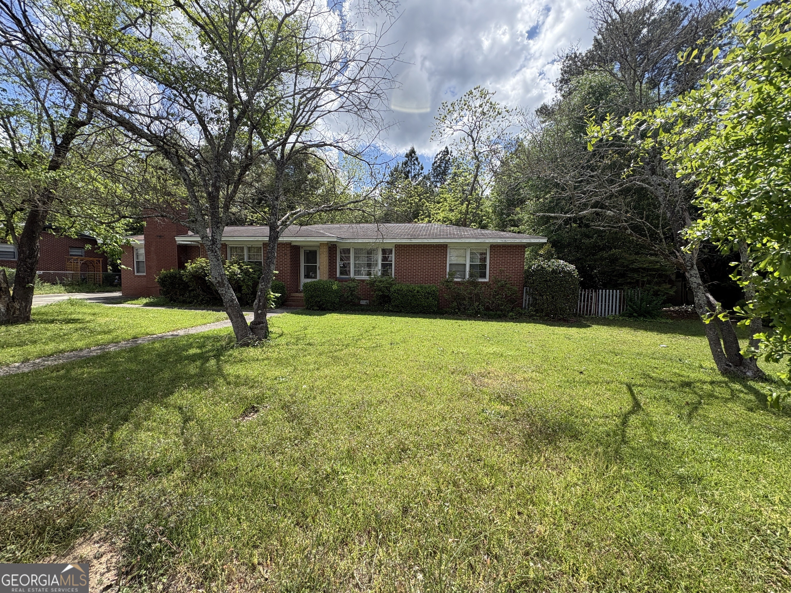 a view of a house with a backyard and a tree