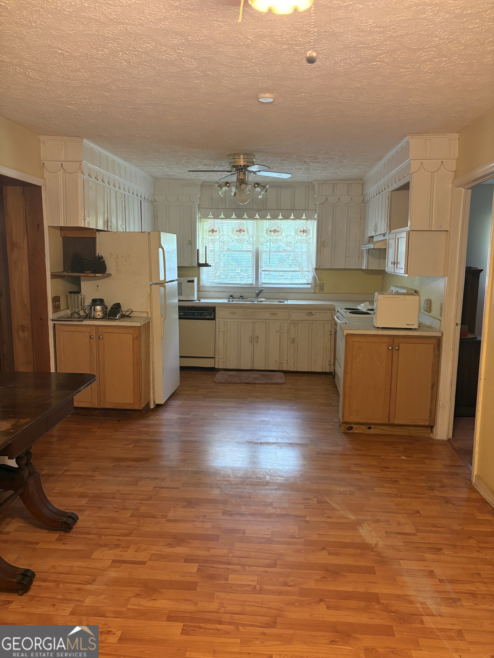 5735 Fitzgerald Street Eastman, GA 31023 - Photo 9 of 22 a large kitchen with a wooden floor and a large window